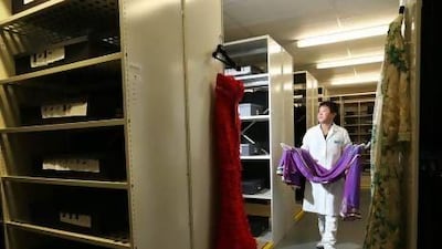 Jin Heng of Vault Couture puts a Middle Eastern kaftan dress away for storage at the company's 24-hour services facility in West London. Only a handful of people know of its secret location. Stephen Lock for the National