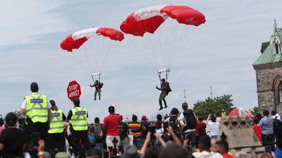 Members of the Canadian Armed Forces parachute team, the SkyHawks, land on the lawn of Parliament Hill on Canada Day in Ottawa, Canada. Bloomberg