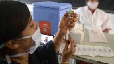 A health worker prepares to inoculate a resident during a vaccination drive for low-income citizens at a school in Hyderabad, India.