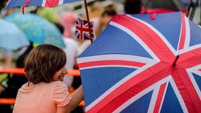 A spectator holding an umbrella in the British national colours waits for Britain's Prince William and Catherine, Duchess of Cambridge at the German Cancer Research Centre in Heidelberg. EPA