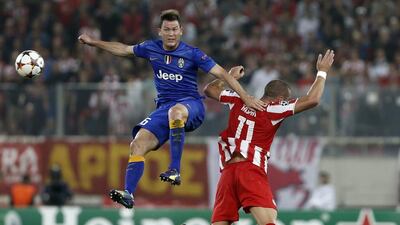 Juventus' Stephan Lichtsteiner, left, and Olympiakos' Pajtim Kasami challenge for the ball during their Champions League group match on Wednesday. Petros Giannakouris / AP