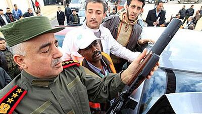 A Syrian officer shows an Arab league monitor, second left, a weapon confiscated from what officials say were gunmen during a monitor's tour in Damascus.