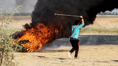 A Palestinian youth swings a sling shot during clashes after a demonstration near the border with Israel. Said Khatib / AFP