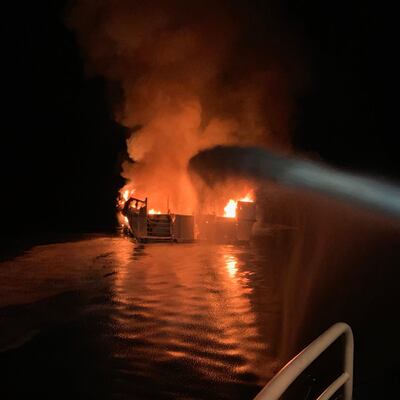Firefighters attempt to put out the boat fire off the coast of Santa Cruz Island. AFP