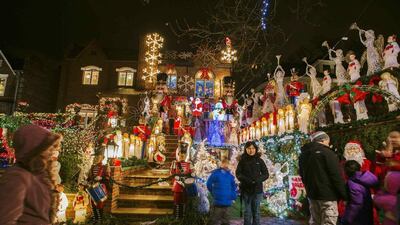 USA: Passerbys stop to have their photograph taken as they look at a house in the Dyker Heights neighborhood of Brooklyn lit up with Christmas decorations in New York. Reuters/Lucas Jackson