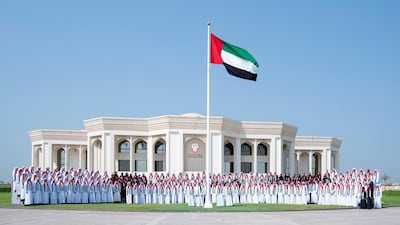 Sheikh Theyab bin Mohamed bin Zayed, Abu Dhabi Executive Council member and Chairman of the Abu Dhabi Crown Prince Court, stands for a photograph with CPC staff members during Flag Day celebrations, at Crown Prince Court. Hamad Al Kaabi / Ministry of Presidential Affairs
