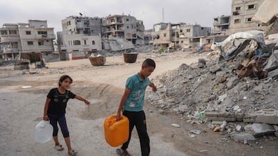 Palestinian children carry water containers in Khan Younis in the southern Gaza Strip. AFP