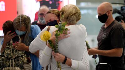 Family members celebrate upon being reunited on arrival at Sydney's international airport. AFP