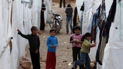 Syrian children play outside their tents at a refugee camp in the city of Arsal in Lebanon's Bekaa valley. (Joseph Eid / AFP)