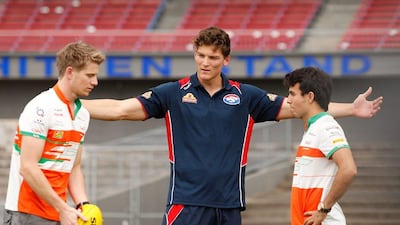 Nico Hulkenberg, left, and Sergio Perez, right, of Force India learn about Australian rules football from Will Minson of the Australian Football League's Western Bulldogs. Darrian Traynor / Getty Images / March 11, 2014
