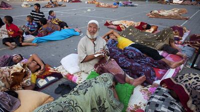 An elderly displaced Palestinian man looks up towards the sky after an explosion was heard nearby as many slept in the courtyard of the UN Jabalya Boys School on July 21, 2014. Heidi Levine for The National