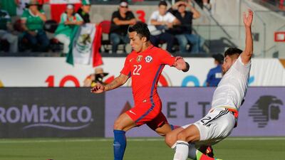 Chile's Edson Puch, left, who played at Al Wasl in the UAE's Arabian Gulf League from 2011-14, avoids Mexico's Nestor Araujo during the Copa America Centenario quarterfinal football match in Santa Clara, California, United States, on June 18, 2016. AFP / Beck Diefenbach