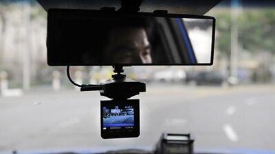 A live video camera is attached to the rear view mirror of a taxi in Singapore. Munshi Ahmed for The National