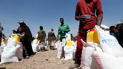 Displaced Yemenis stand next to food rations provided by Mona Relief Yemen before an international donor conference on Yemen. EPA