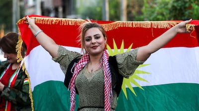 An Iraqi Kurdish woman poses with the flag of Iraqi Kurdistan during a demonstration outside the United Nations office in Erbil, the capital of Iraq's autonomous Kurdish region, on October 21, 2017, protesting against the escalating crisis with Baghdad. Safin Hamed / AFP