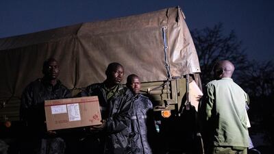 Ugandan soldiers unload pesticide solution to be used against invading locusts. Getty Images