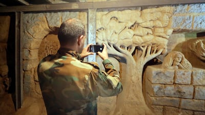 A pro-regime Syrian soldier photographs a sculpture. EPA
