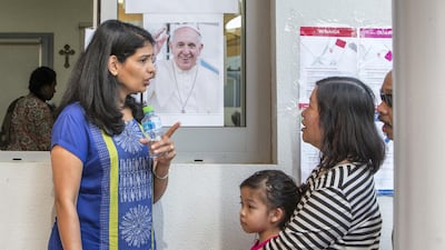 A volunteer provide information to people regarding the papal mass.