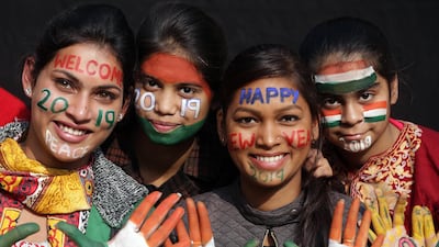 Indian girls, with their faces painted with slogans to welcome the new year and Indian flags, pose for photographs as they celebrate in Amritsar, India. EPA