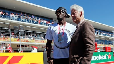 Eight time Olympic gold medal winner Usain Bolt and former US President Bill Clinton stand on the track before the start of the race. Tony Gutierrez / AP Photo
