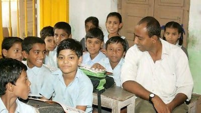 Mamoon Akhtar, the founder of Samaritan Help Mission, joins students at one of its schools. Courtesy Samaritan Help Mission