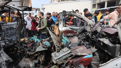 Palestinians at the site of the strike on a police car. AFP