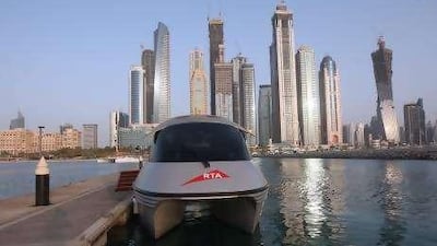 The skyline forms a scenic backdrop for a water taxi parked at its station at Dubai Marina.