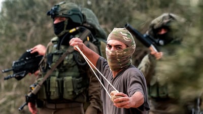 Israeli soldiers and a man armed with a slingshot during an attack by settlers on the Palestinian village of Beita on October 10. The occupation of the West Bank is accompanied by a two-tier justice system and security forces unwilling or unable to rein in militant settlers. AFP
