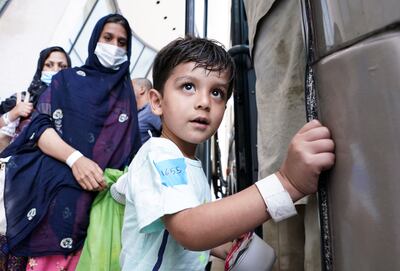 An Afghan boy boards a bus taking refugees to a processing centre at Dulles International Airport. Reuters