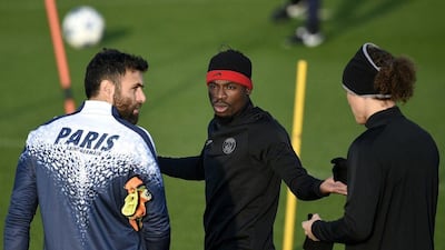 Serge Aurier, centre, speaks to PSG teammates Salvatore Sirigu, left, and David Luiz, right, during their training session on Monday. Franck Fife / AFP