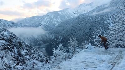 A boy removes snow from his house in Neelum valley, Pakistani administered Kashmir. EPA