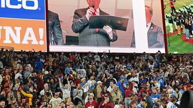US President Donald Trump reads the oath for people re-enlisting to the army as he attends the NFL game between Washington Commanders and Detroit Lions at North-west Stadium in Landover, Maryland. AFP