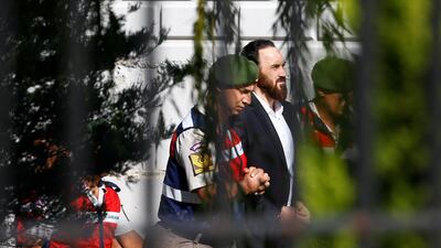 An unidentified soldier accused of attempting to assassinate Turkish president Recep Tayyip Erdogan on the night of the failed July 15 coup last year is escorted by gendarmes as he leaves from the final hearing of the trial in Mugla, Turkey, on October 4, 2017. Osman Orsal / Reuters