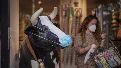 A novelty cow figure stands at the entrance to a clothing and accessories store in Madrid, Spain. Bloomberg
