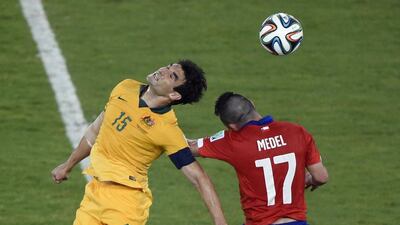 Mile Jedinak, left, of Australia heads the ball against Gary Medel, right, of Chile, during their World Cup Group B match on Friday in Cuiaba, Brazil. Juan Barreto / AFP