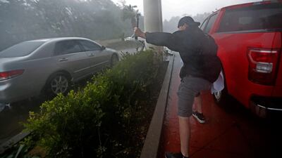 A storm chaser films from underneath a hotel canopy in Panama City Beach. AP