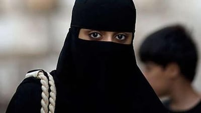 A woman wears the niqab, above, an uncommon sight in Damascus, where most Syrians prefer to wear a hijab, below. The education ministry has banned women who wear niqabs from teaching in primary schools, saying it undermines Syria's tradition of a secular education system.