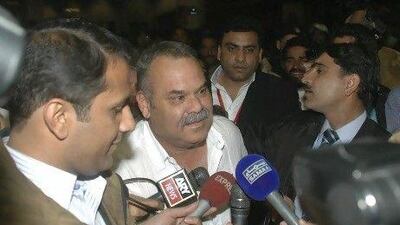 Australian Dav Whatmore, centre, is surrounded by reporters upon his arrival at Lahore airport in Pakistan today. Hamza Ahmed / AP Photo