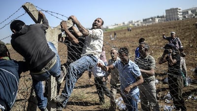 Turkish and Syrian Kurds tear down the border fence to cross into neighbouring Syria during a demonstration near the Mursitpinar border crossing in Sanliurfa province on September 26. AFP