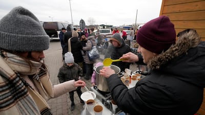 Refugees fleeing the fighting in Ukraine queue for hot drinks at the border crossing in Medyka, south-east Poland. AP Photo