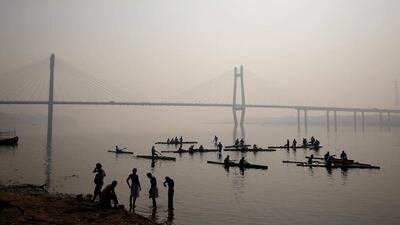 People bathe on the banks of the Ganges on February 20, 2014, as entrants in the Ganga water rally pass by in Allahabad, India. The rally, which goes from Allahabad to to Varanasi, is organised by the Indian Kayaking and Canoeing Association, Allahabad Boat Club and Uttar Pradesh state Tourism to promote water sports. Rajesh Kumar Singh / AP photo