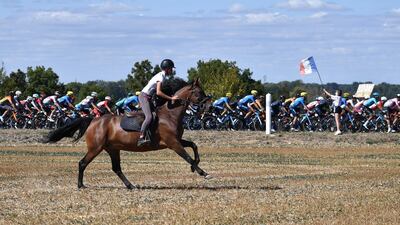 A woman on horseback keeps up with the action on Stage 11. AFP