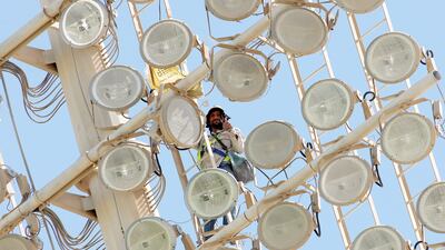 A maintenance worker on one of the floodlights at Zayed Cricket Stadium in Abu Dhabi - one of the many unsung heroes of UAE cricket. Pawan Singh / The National
