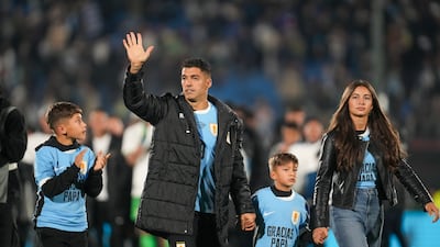Uruguay's Luis Suarez waves to fans, accompanied by his children, after his final match for his country in a goalless draw against Paraguay. AP