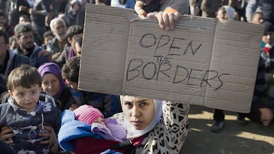 Stranded refugees and migrants protest in front of the wire fence that separates the Greek side from the Macedonian one at the northern Greek border station of Idomeni, February. 27. AP Photo/Petros Giannakouris
