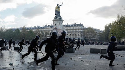 Police officers charge against protesters. AFP