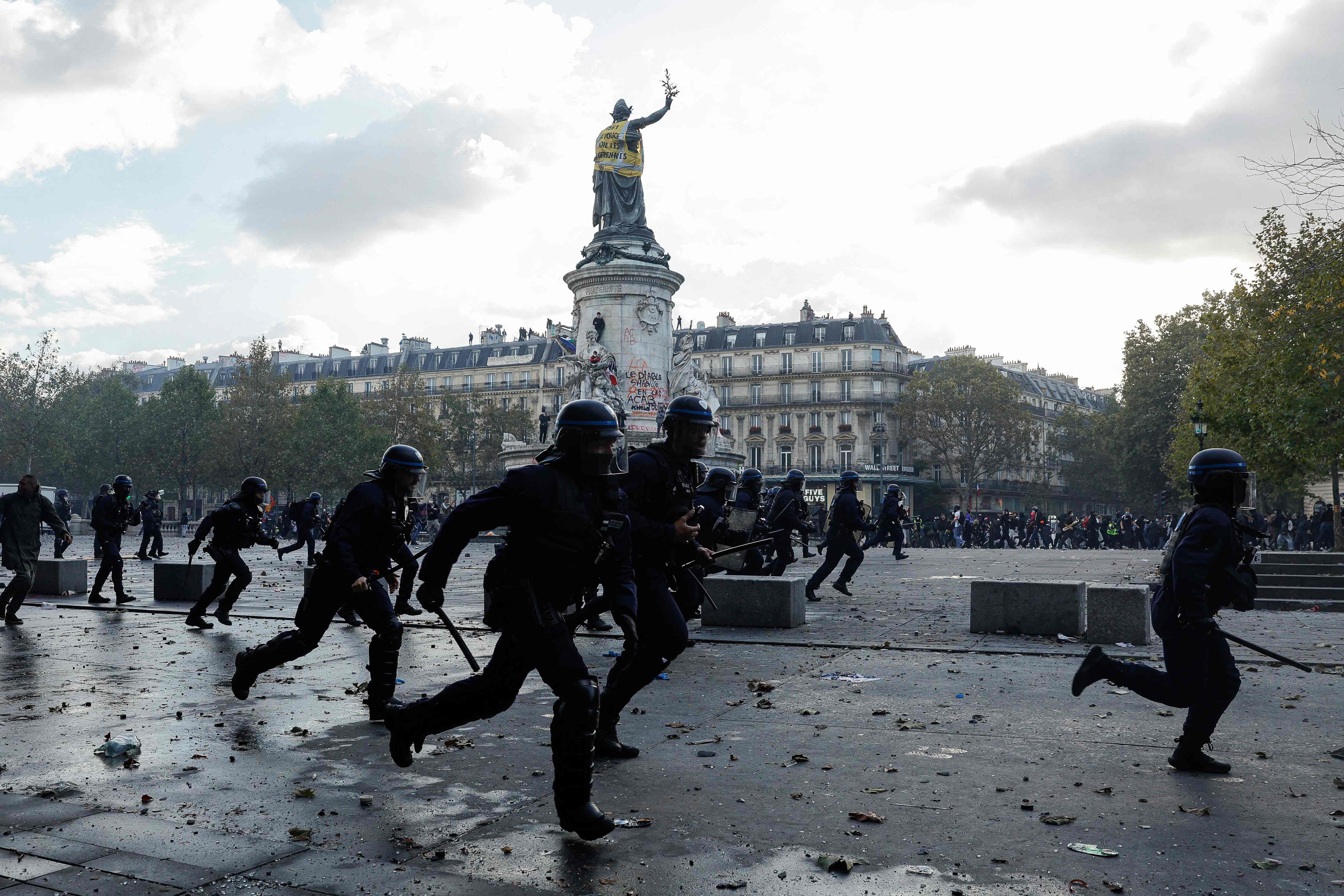 Police officers charge against protesters. AFP