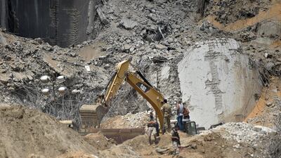 Workers and members of Lebanese civil defense search for bodies and survivors amid the rubble. EPA