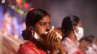 A devotee blows a conch shell at Sagar Island. EPA