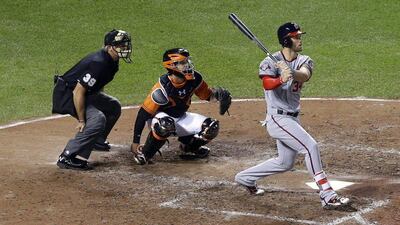 Washington Nationals' Bryce Harper, right, watches his solo home run in front of Baltimore Orioles catcher Caleb Joseph and home plate umpire Paul Nauert in the sixth inning of an interleague baseball game, Saturday, July 11, 2015, in Baltimore. (AP Photo/Patrick Semansky)